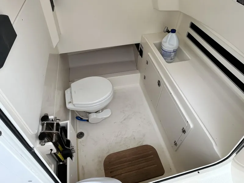 Slide: The Image of 2018 Boston Whaler 330 Outrage boat interior with toilet and storage area. - 24
