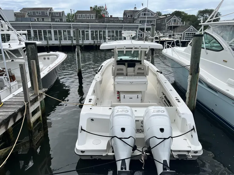 Slide: The Image of 2018 Boston Whaler 330 Outrage docked at marina, rear view with twin engines. - 8