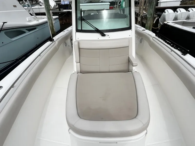 Slide: The Image of 2018 Boston Whaler 330 Outrage boat interior with cushioned seating and windshield. - 26