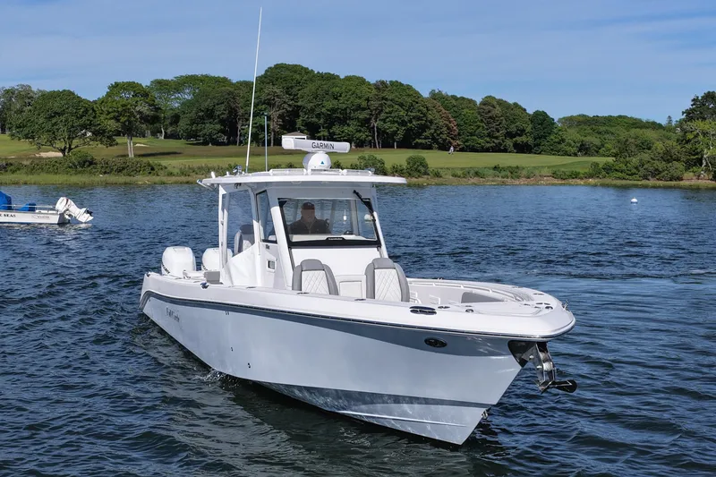 Slide: The Image of 2022 Everglades 365 Center Console boat cruising on a scenic lake. - 11
