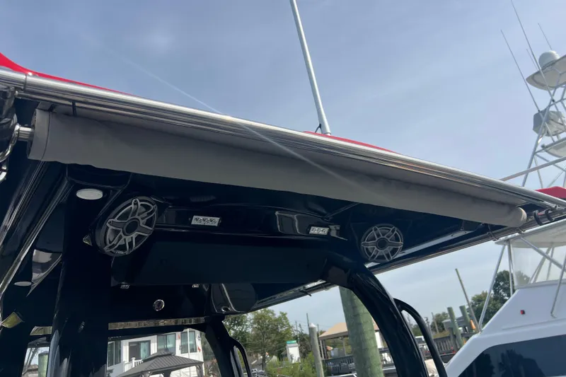 Slide: The Image of 2021 Fountain 39 NX boat with speakers and canopy, docked under clear sky. - 12