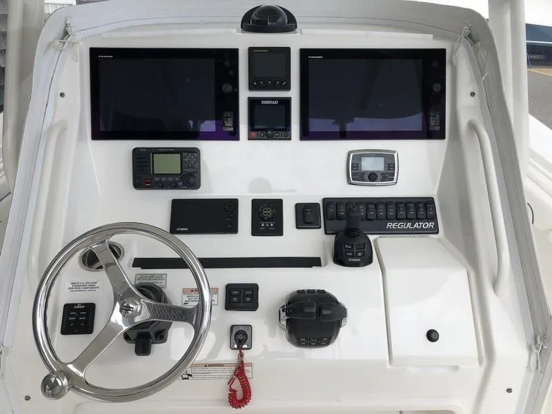 Slide: The Image of Control panel of a 2018 Regulator 31 boat with steering wheel and electronic displays. - 14