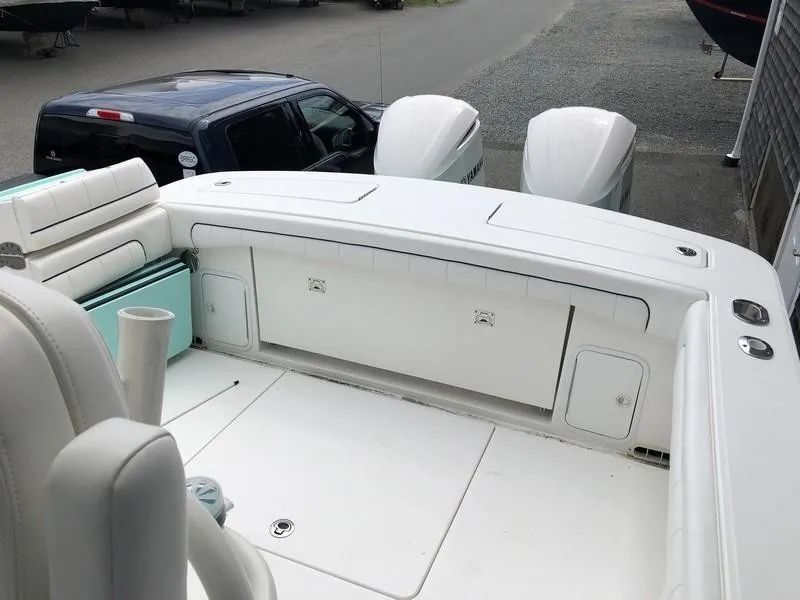 Slide: The Image of 2018 Regulator 31 boat with dual outboard engines, spacious deck, and seating area. - 16