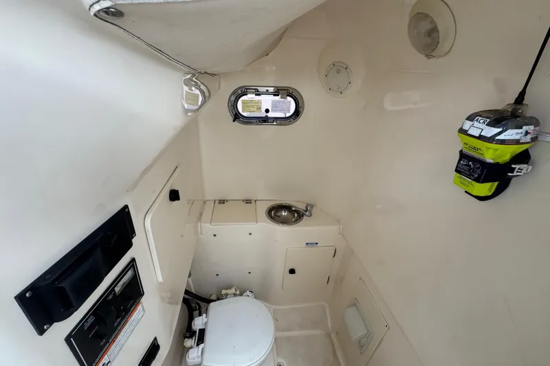 Slide: The Image of Interior of 2011 Pursuit C 280 Center Console boat with compact bathroom amenities. - 14