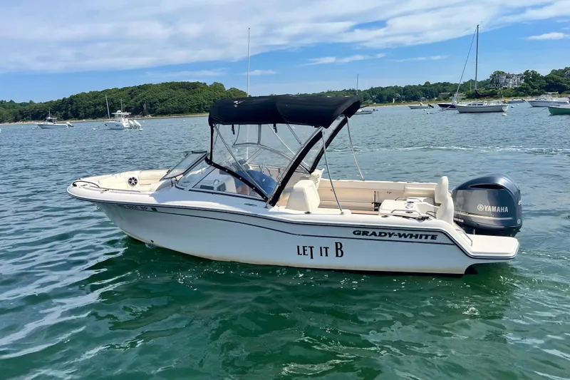 Slide: The Image of 2021 Grady-White Freedom 215 boat on water, featuring Yamaha engine and canopy. - 2