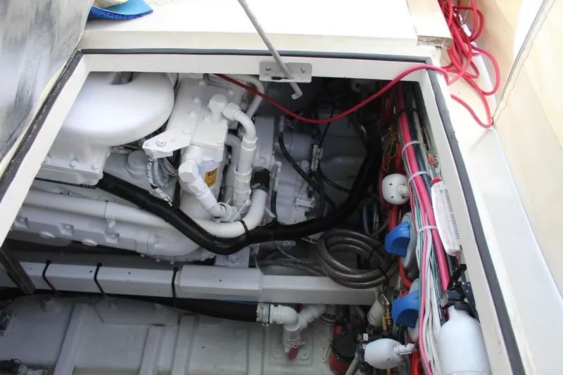 Slide: The Image of Engine compartment of a 1985 Viking Express boat, showcasing wiring and mechanical components. - 23