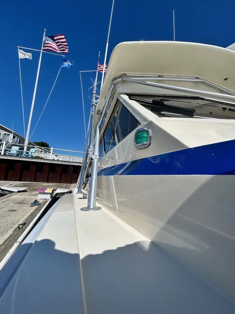 Slide: The Image of 1985 Viking Express boat docked, featuring sleek design and vibrant blue stripe under clear sky. - 10