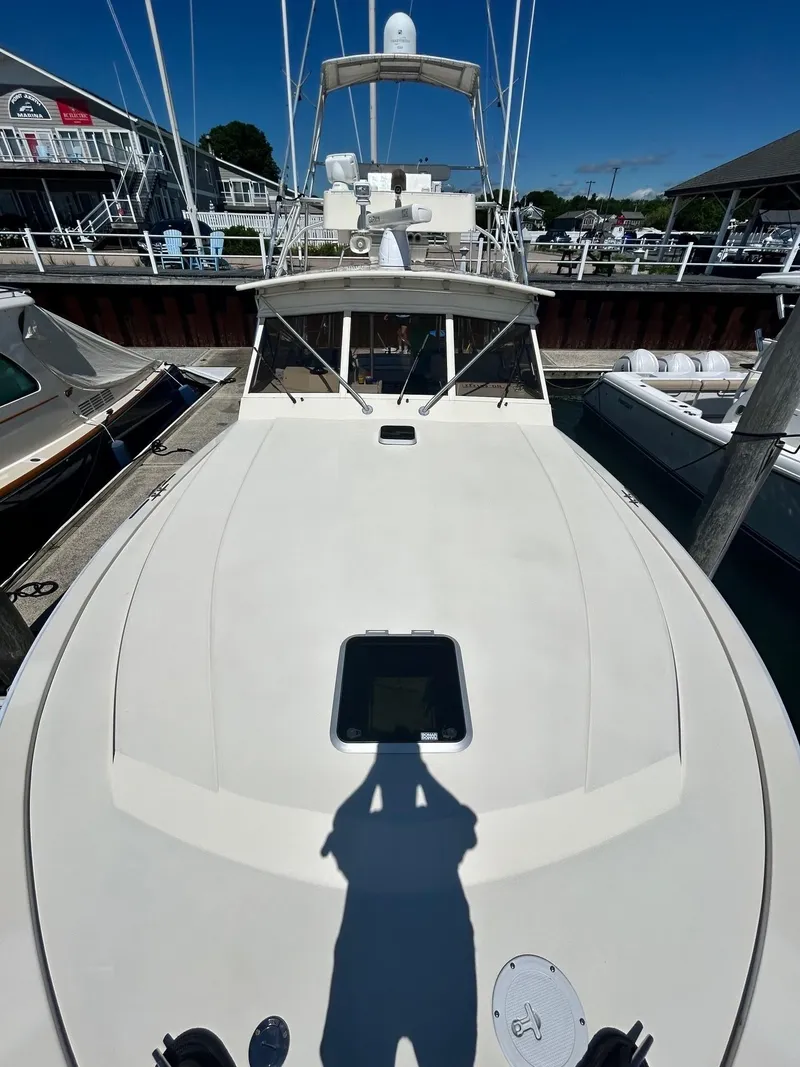 The Image of 1985 Viking Express boat docked at a marina under clear blue skies. - 14