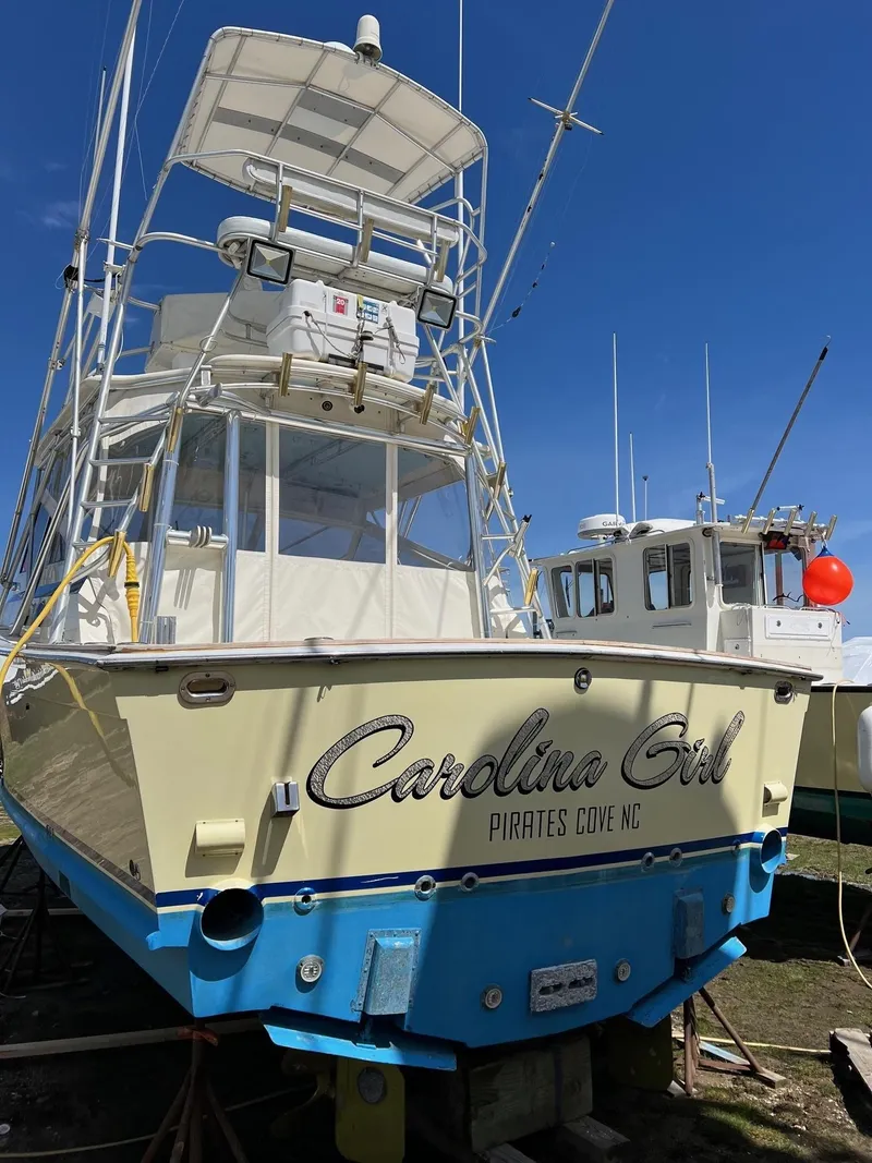 Slide: The Image of 1985 Viking Express boat "Carolina Girl" at Pirates Cove, NC, under clear blue sky. - 29