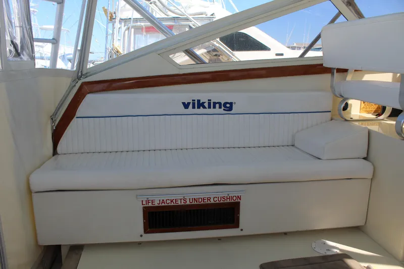 Slide: The Image of 1985 Viking Express boat interior with white seating and life jacket storage. - 15