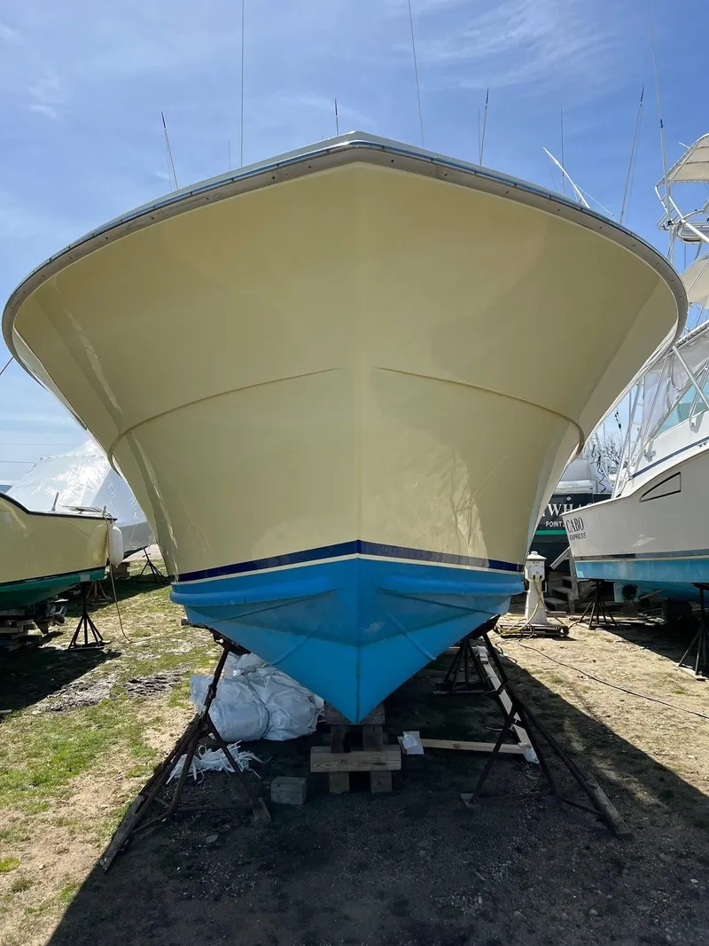 Slide: The Image of 1985 Viking Express boat on dry dock, yellow hull, blue bottom, clear sky background. - 2