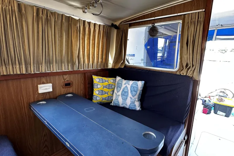 Slide: The Image of Interior of 1980 Bertram 33 Sport Fisherman with seating and nautical-themed pillows. - 16