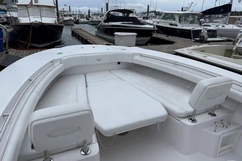 Slide: The Image of 2018 Southport 33 FE boat with white seating, docked at a marina. - 18