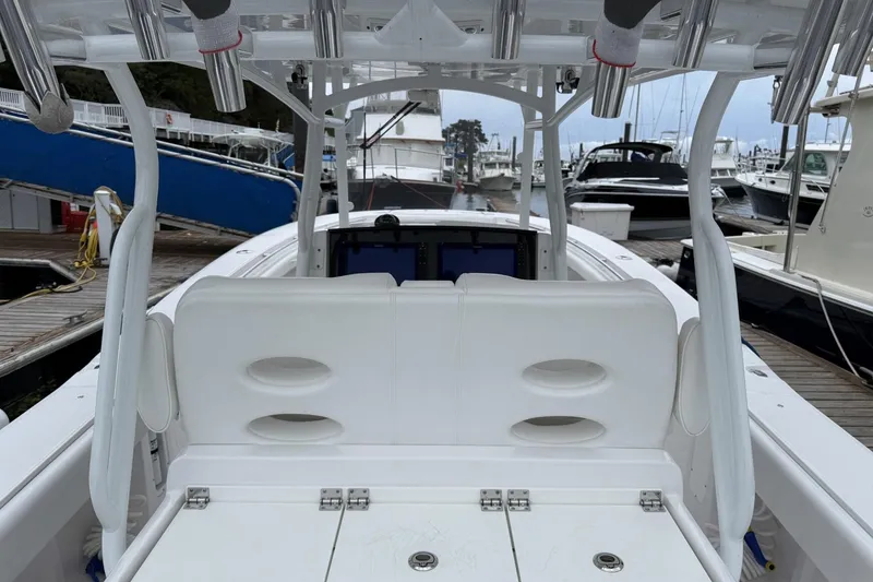 Slide: The Image of 2018 Southport 33 FE boat interior at marina, featuring white seating and rod holders. - 13