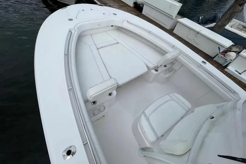 Slide: The Image of 2018 Southport 33 FE boat interior with white seating and deck, docked by the water. - 21