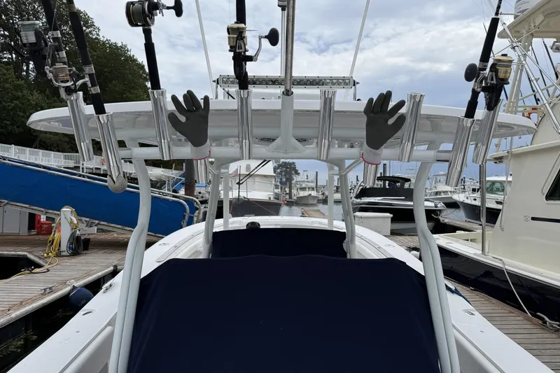 Slide: The Image of 2018 Southport 33 FE boat with fishing rods and gloves at a marina. - 10