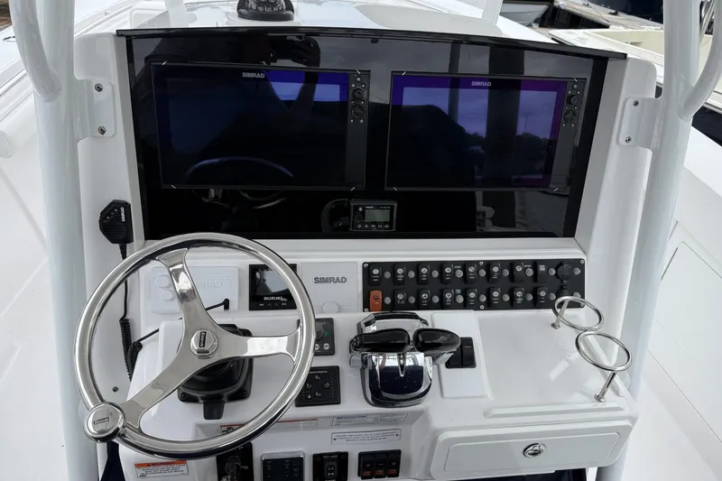 Slide: The Image of 2018 Southport 33 FE boat dashboard with steering wheel and dual Simrad displays. - 16
