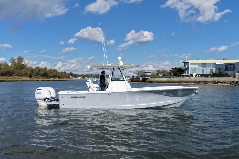 The Image of A 2025 Regulator 28 boat on calm water with blue sky and clouds. - 1
