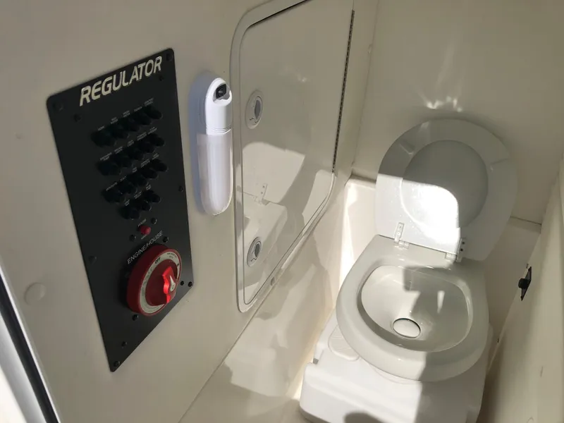 Slide: The Image of 2022 Regulator 26XO boat interior with control panel and toilet. - 14