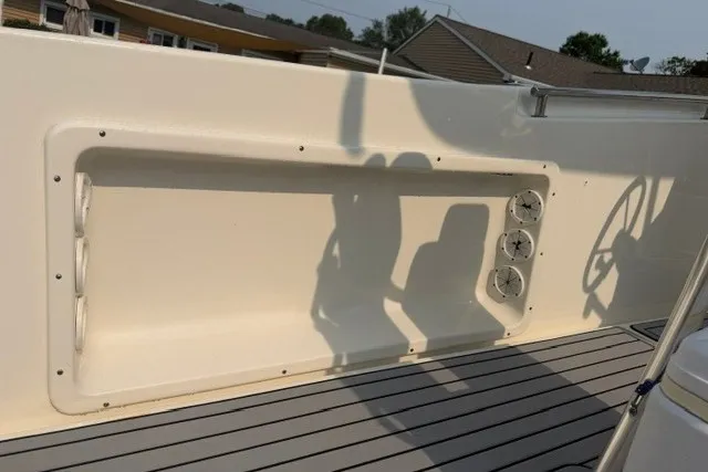 Slide: The Image of 2021 Bulls Bay 230 Center Console boat interior with rod holders and steering wheel shadow. - 16