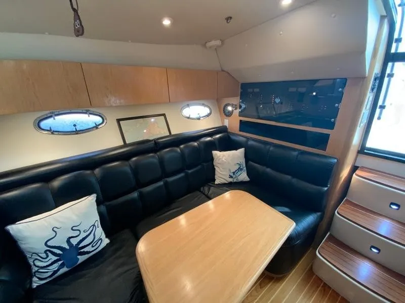 Slide: The Image of Interior of 2002 Tiara Yachts 3500 Open with leather sofa and wooden table. - 17