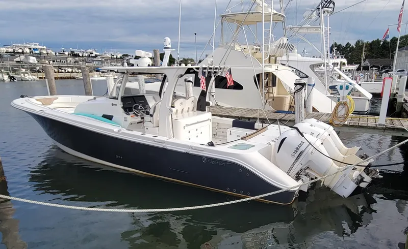 The Image of 2018 Edgewater 370CC boat docked in marina, featuring sleek design and powerful engines. - 1
