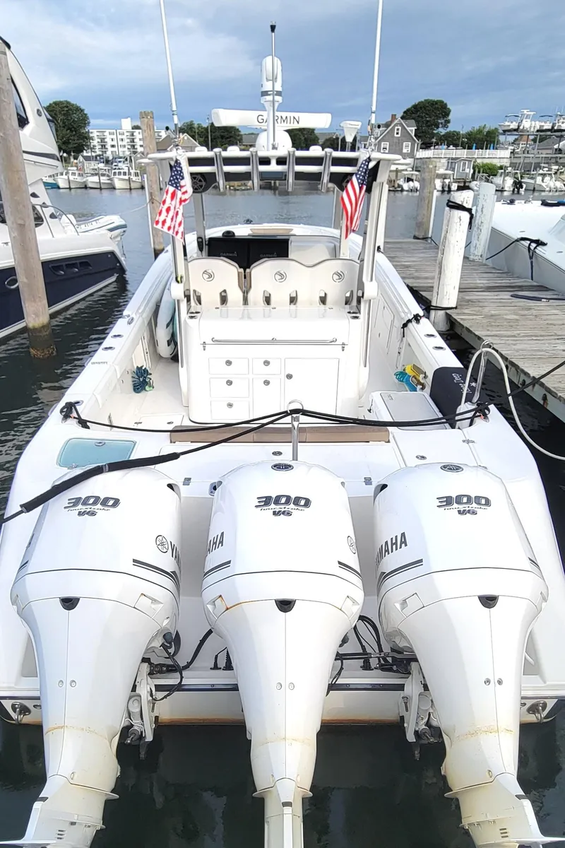 Slide: The Image of 2018 Edgewater 370CC boat with triple Yamaha 300 engines docked at marina. - 18
