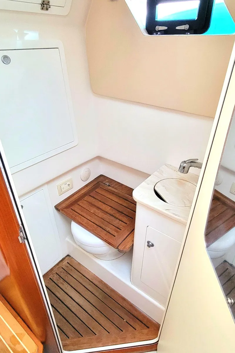 Slide: The Image of 2018 Edgewater 370CC boat bathroom with wooden accents and compact sink. - 15