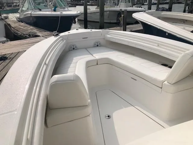 Slide: The Image of 2019 Regulator 23 Forward Seating with spacious cushioned bow seating, docked at a marina. - 14