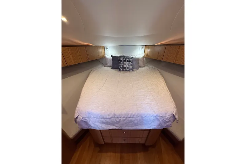 Slide: The Image of 2023 Tiara Yachts 4300 Open cabin interior with cozy bed and wooden cabinetry. - 26