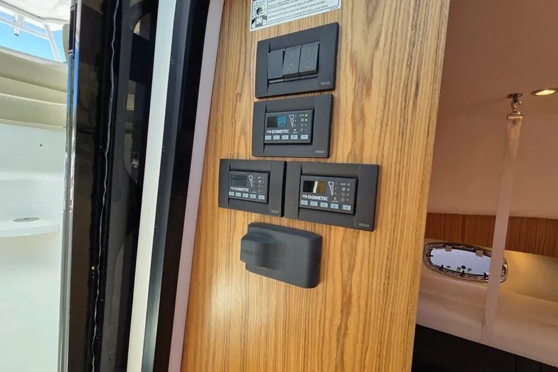 Slide: The Image of Control panel inside 2023 Tiara Yachts 4300 Open, featuring Dometic systems and modern wood finish. - 19