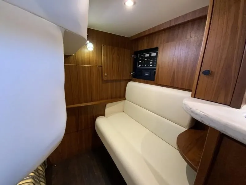 Slide: The Image of Interior of 2013 Tiara Yachts 36, featuring a cozy seating area and wooden paneling. - 24