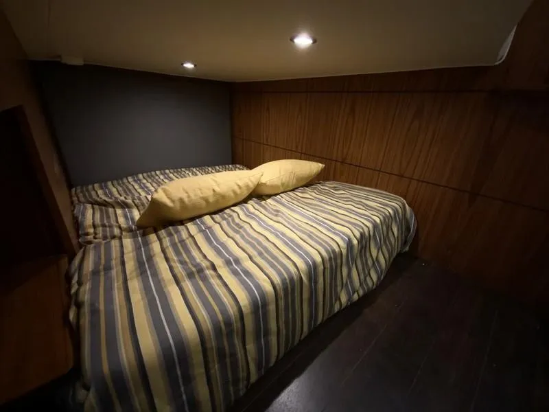 Slide: The Image of Cozy cabin interior of 2013 Tiara Yachts 36 with striped bedding and wooden walls. - 22