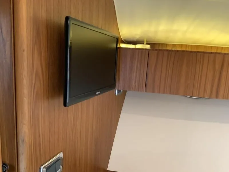 Slide: The Image of Interior of 2013 Tiara Yachts 36 with mounted TV and wooden cabinetry. - 21