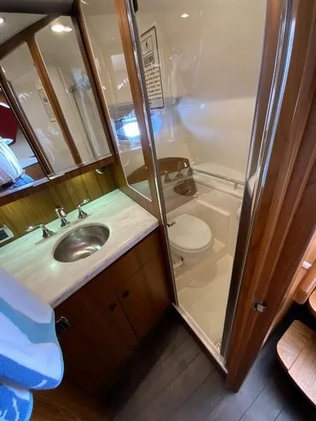 Slide: The Image of 2013 Tiara Yachts 36 bathroom with sink, shower, and wooden cabinetry. - 23