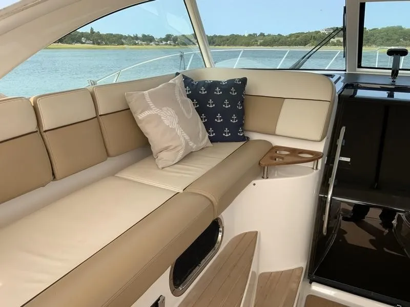 Slide: The Image of Luxurious interior of 2013 Tiara Yachts 36 with beige seating and nautical-themed pillows. - 13