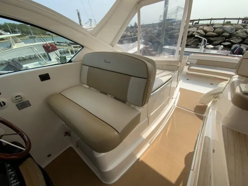 Slide: The Image of Interior of 2013 Tiara Yachts 36, featuring beige seating and helm area. - 14
