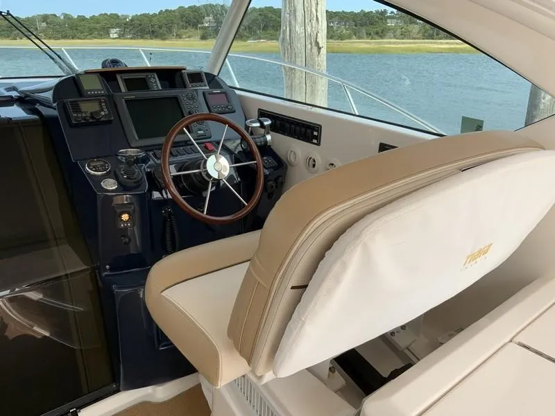 Slide: The Image of 2013 Tiara Yachts 36 helm with beige seating and advanced navigation controls. - 12