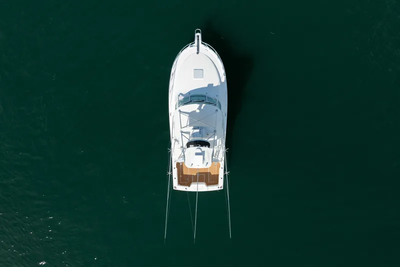 Slide: The Image of Overhead view of a 2011 Cabo 36 Express boat on dark water. - 16