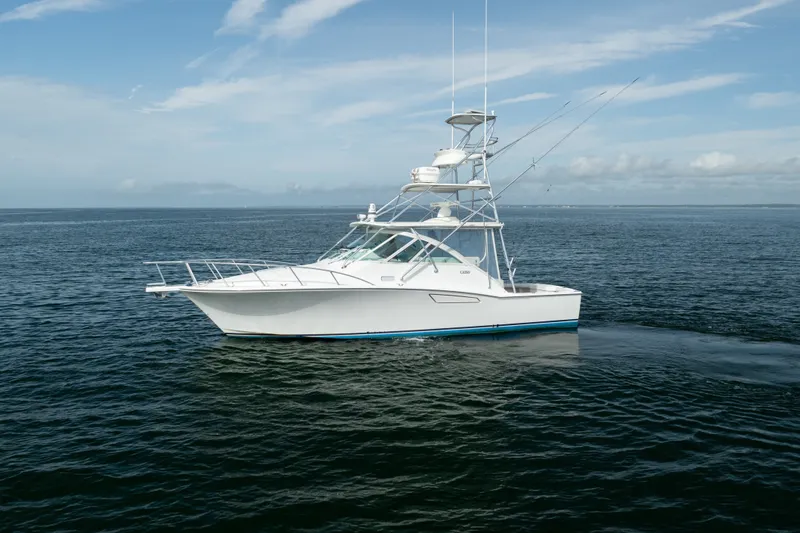 Slide: The Image of 2011 Cabo 36 Express yacht cruising on open water under a clear sky. - 6