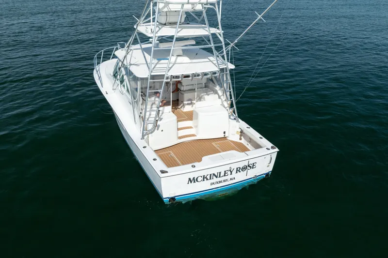 Slide: The Image of 2011 Cabo 36 Express boat on water, rear view, named "McKinley Rose." - 17