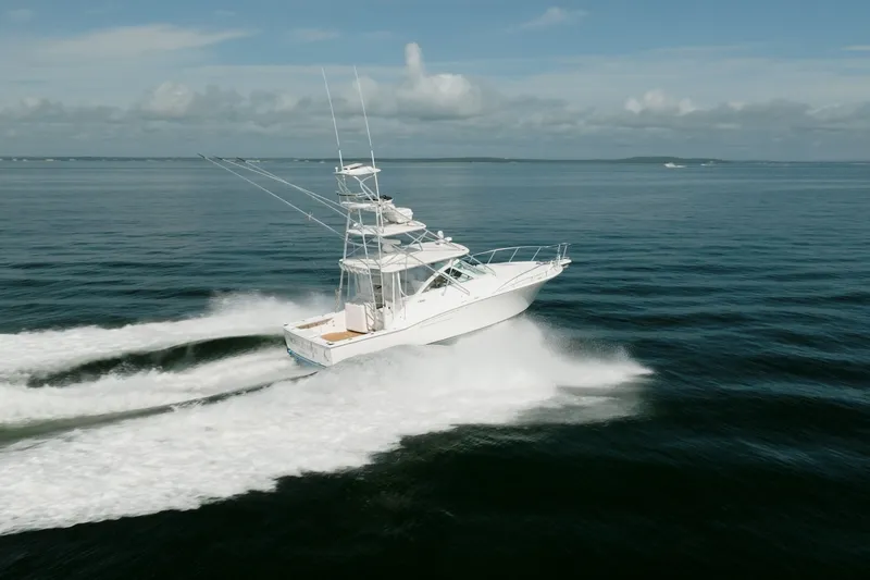 Slide: The Image of 2011 Cabo 36 Express yacht cruising on open water under a clear sky. - 3
