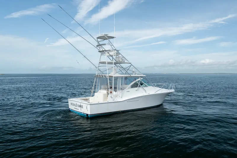 Slide: The Image of 2011 Cabo 36 Express boat on open water under a clear blue sky. - 13