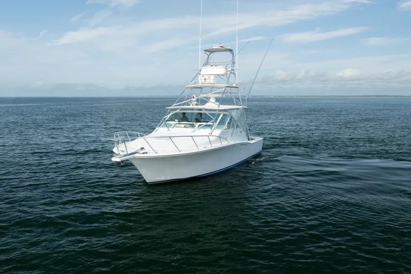 Slide: The Image of 2011 Cabo 36 Express boat cruising on open water under a clear sky. - 8