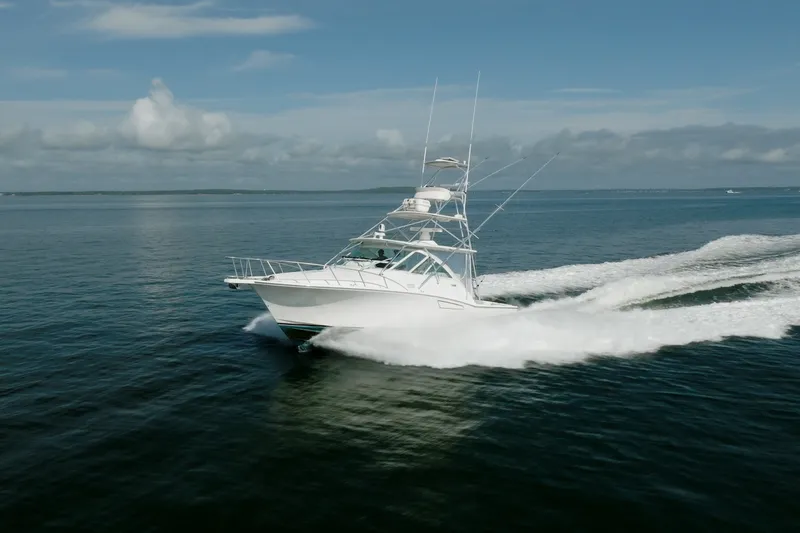 Slide: The Image of 2011 Cabo 36 Express yacht cruising on open water under clear skies. - 1