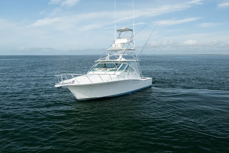 Slide: The Image of 2011 Cabo 36 Express boat cruising on open water under a clear sky. - 7