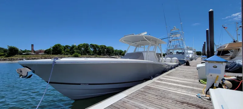 Slide: The Image of 2018 Regulator 41 Center Console boat docked at a marina on a sunny day. - 17