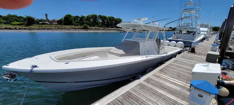 Slide: The Image of 2018 Regulator 41 Center Console boat docked at a marina on a sunny day. - 18