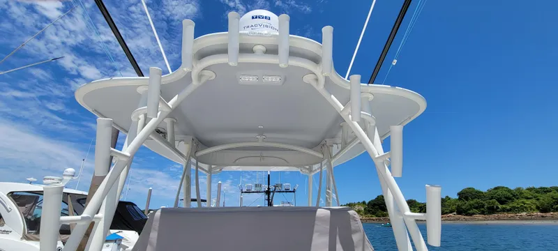 Slide: The Image of 2018 Regulator 41 Center Console boat with T-top and rod holders on a sunny day. - 15