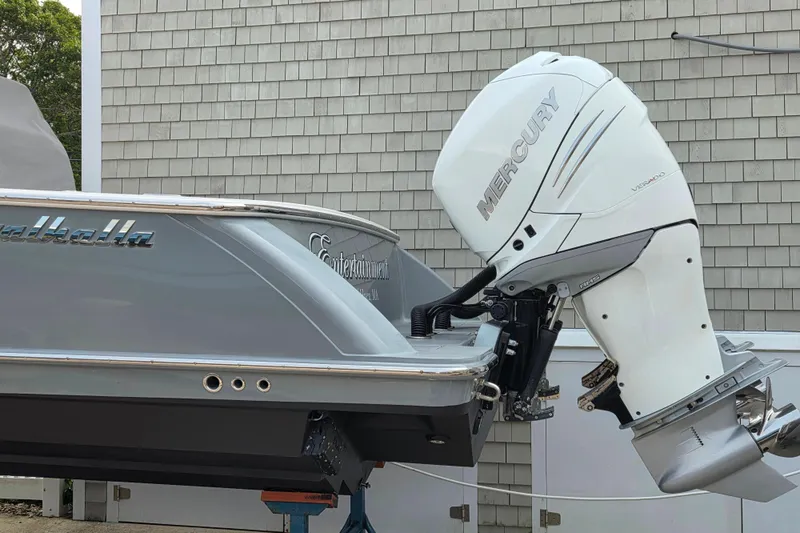 Slide: The Image of 2021 Valhalla Boatworks V-33 with Mercury outboard engine, docked near a shingled building. - 23